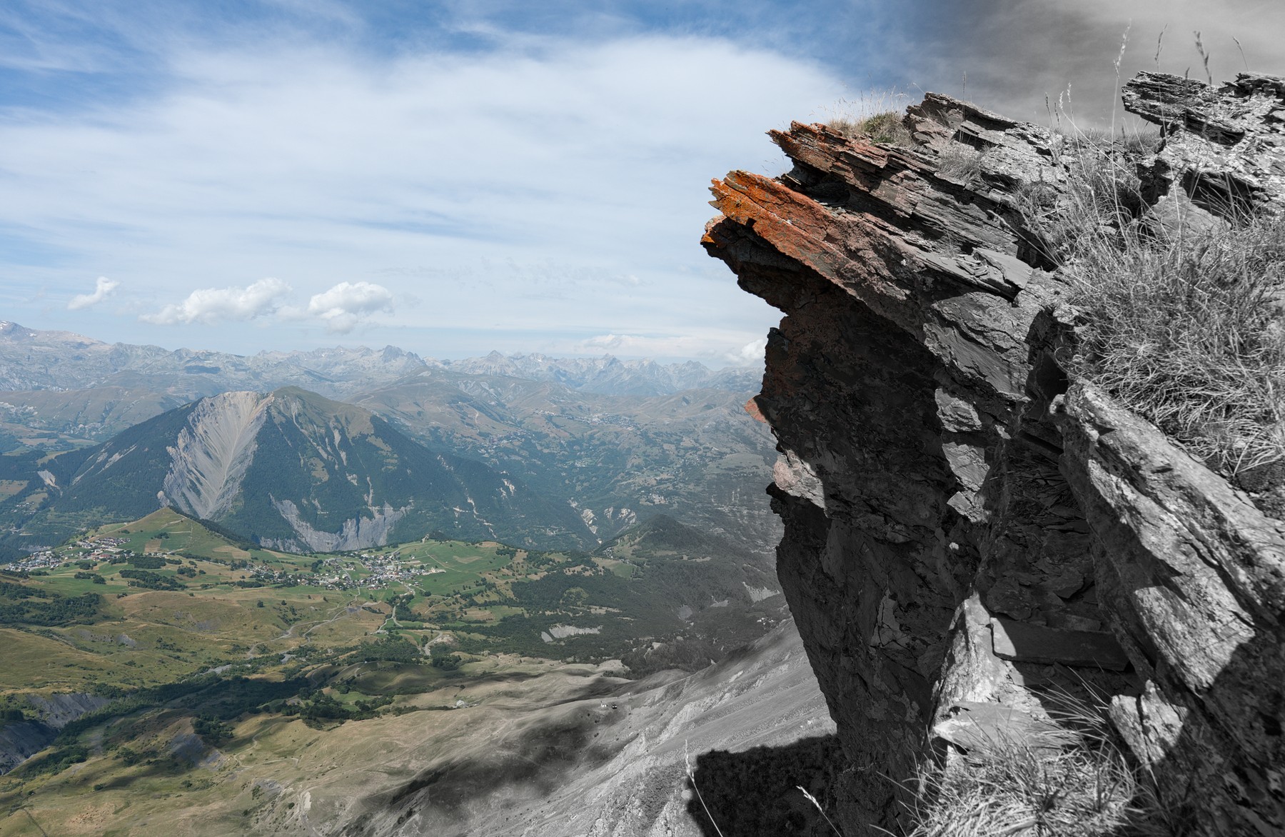 Photo d’un paysage de montagne en couleur sur sa partie gauche et en noir et blanc sur sa partie droite